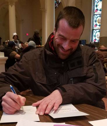 Holy Apostles soup kitchen guest Peter, at The Writing Den’s December 2018 event, sent holiday cards to family members. Photo: Jill Higson