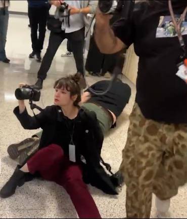 A photojournalist, later identified as Olga Federova, came up shooting her camera after she was shoved into a wall by ICE agents. It all started when <i>amNY </i>journalist Dean Moses was forced from an elevator. Behind her, on the floor, is a Turkish journalist, L. Vural Elibol, who suffered a head injury and was taking away on a stretcher.