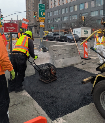 DOT worker tamping down the Williamsburg “Bump” to make a “Zohramp.”