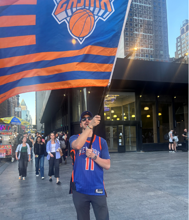 A fan waves a Knicks flag outside Madison Square Garden before the start of game 1.
