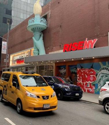 RiseNY at 160 West 45th Street has a decidedly New York flair at its entrance, just east of Broadway and Seventh Avenue. You are able to stand under that torch at the conclusion of your visit. Photo: Ralph Spielman