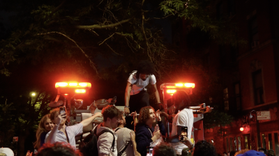 Fans climb aboard a stationary FDNY truck, celebrating the big win.