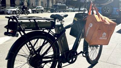 The e-bike of a Burkina Faso delivery driver who uses lithium batteries that he charges at home. Another fully charged battery is stored at the back of his bike. The pilot program hopes to lessen the residential fire danger. Photo: Alessia Girardin.