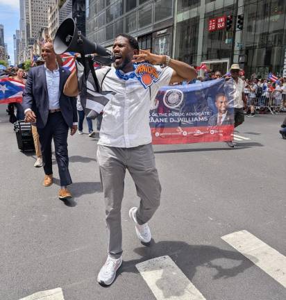 Comptroller Jumaane Williams with a Knicks medallion and black and white Puerto Rican nationalist flag.