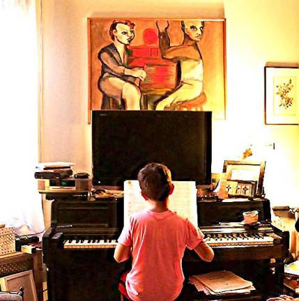 A young boy plays piano in his mother's East Village apartment.