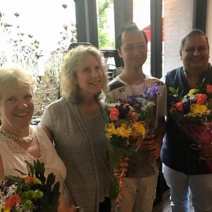 From left to right: Marcia Eckert, Deborah Gilwood, intern/percussionist Brendan Ko and Raj Bhimani receive flowers from students at a dinner after the closing recital.
