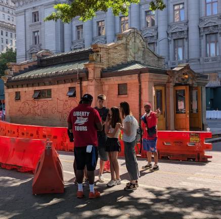 Tour guide hustlers work their marks near Bowling Green subway station.