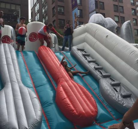 A child rides down between inflatable cutlery on the LG Quadwash waterpark slide. Photo: Bryse Ciallella