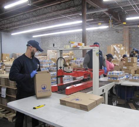 At the Citymeals Emergency Meal Center, packing shelf-stable meals in boxes for delivery.