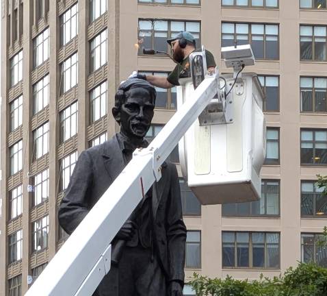 Duarte Square monument gets Parks Department Summer Glow-up. Here a worker from the monuments crew uses blowtorch and polishing tower to make Duarte shine.