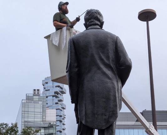 Duarte Square monument gets Parks Department Summer Glow-up. Here a worker from the monuments crew uses blowtorch and polishing tower to make Duarte shine.