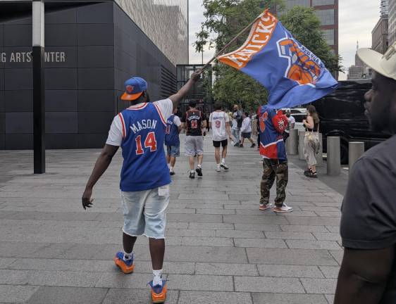 Knicks parade pilgrim Django from the Bronx in No. 14 Anthony Mason jersey waves flag.