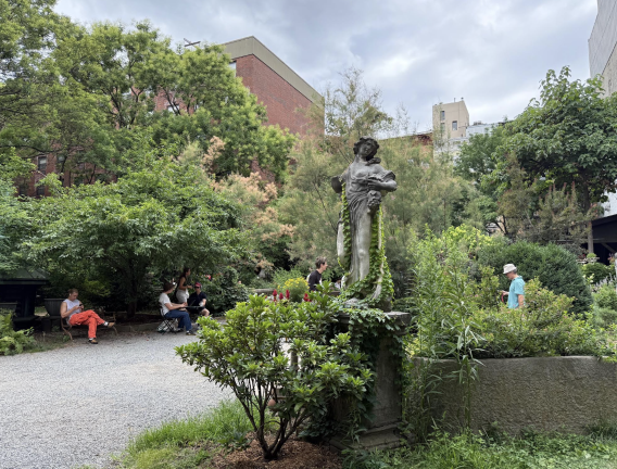 Visitors relax under shade trees inside Elizabeth Street Garden on July 20. Only weeks earlier, the Adams administration reversed course and said it would build affordable housing elsewhere rather than evict the garden from the city-owned land.
