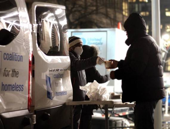Volunteers from the Coalition for the Homeless serve pre-packaged food to those in need as a part of the organization’s Grand Central Food Program. Photo courtesy of Coalition for the Homeless