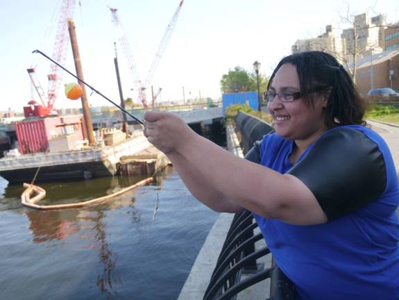 Anairis Marmolejos baits her hook before casting into the East River at East 92nd Street and the FDR Drive. Photo: William Mathis.