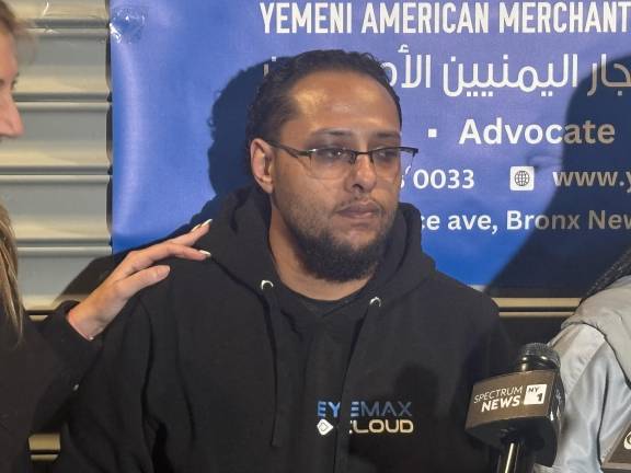 Yasef Yafi, a cousin of slain bodega worker Abdul Salen is comfored by a local minister at a candlelight vigil on April 29. He was too distraught to speak to the crowd, but spoke to Our Town Downtown. His dying cousin’s last words were, ‘take care of my kids,” Yafi said.