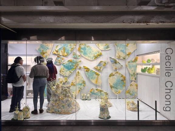 Commuters view <i>Chicken Little – Líneas de Falla / Fault Lines</i> by Cecile Chong through the windows of Whitebox Portable inside the Times Square transit hub.