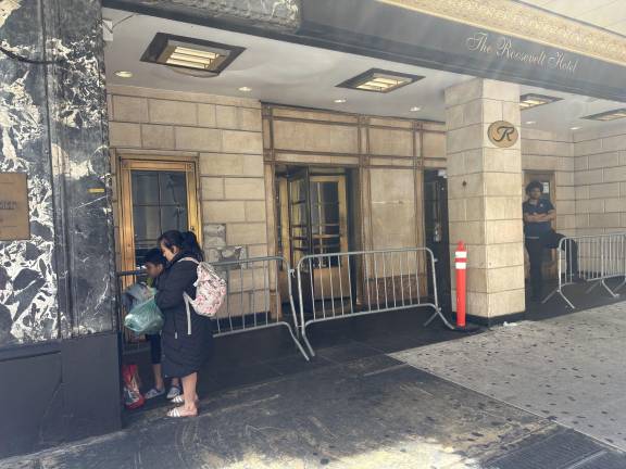 A young mom huddles with her son outside the Roosevelt Hotel.