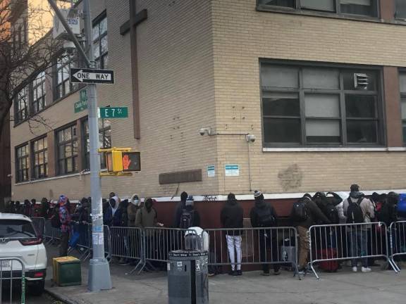 Migrants in line trying to get entry to migrant center in the former St. Brigid School in the East Village
