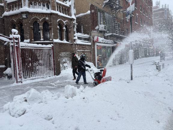 Snowblower clears snow outside Immaculate Conception Church on E. 14th St.