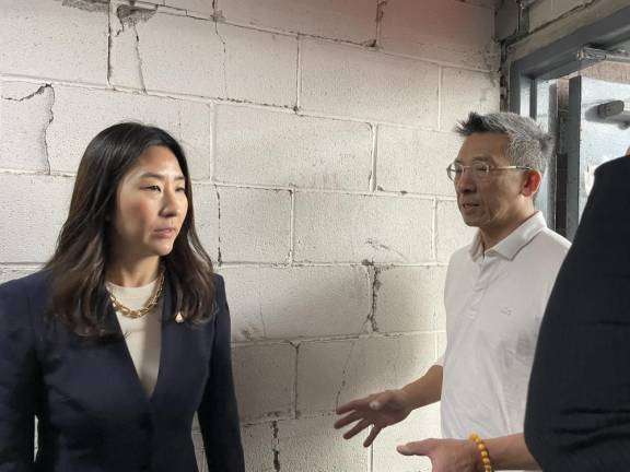 Neighbors United Below Canal leader and local landlord Jan Lee shows New York Assemblymember Grace Lee the damage inside the Chung Pak Centre Street exit corridor.