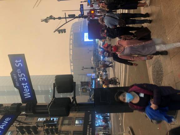 <b>As a yellow haze driven by Canadian forest fires enveloped the city for a second day, many pedestrians were once again sporting masks.</b> Photo: Keith J. Kelly