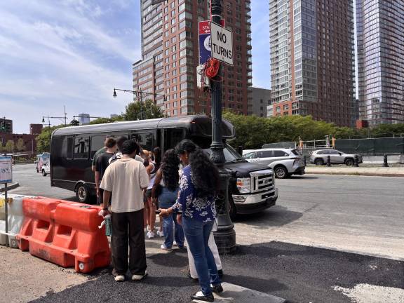 Visitors line up to board a shuttle bus headed to a sightseeing cruise departure point.