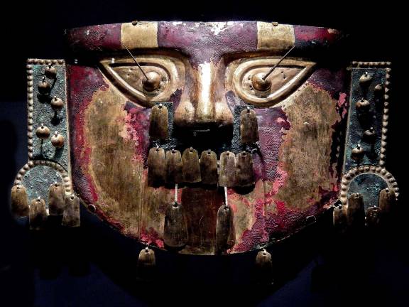 A fearsome funerary mask in of hammered sheet gold alloy and covered in red pigment, once adorned the body of a deceased ruler on Peru’s north coast. Photo: Adel Gorgy