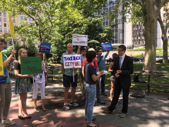 Aaron Foldenauer, right, a City Council candidate, speaking about a federal criminal complaint he filed Wednesday morning, alleging that his rights to free speech were violated when NYPD officials confiscated campaign literature prior to allowing him and others into a June 21 event hosted by Council Member Margaret Chin and Mayor Bill de Blasio.