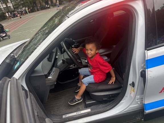 A youngster sits in the front seat of a police cruiser and gets to sound the siren at the National Night Out event staged by the 19th Precinct at St. Catherine’s Park on the UES.