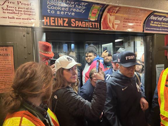 Yankee fans swarm on board the Nostalgia Express train enroute to Opening Day at Yankee stadium. Notice the vintage advertisements overhead. Many fans had to be left stranded on the platform as the jam packed express train ran non-stop to Yankee stadium.