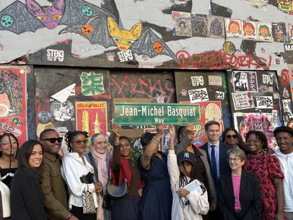 City officials and Basquiat family members holding up the new street sign in front of 57 Great Jones St.