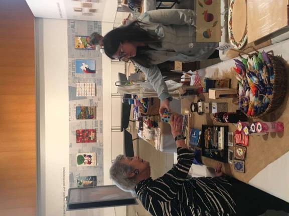 Just One Job participant Emily Mann selling merchandise to a customer of the JCC's Shabbat Shop. Photo: Michael Rock