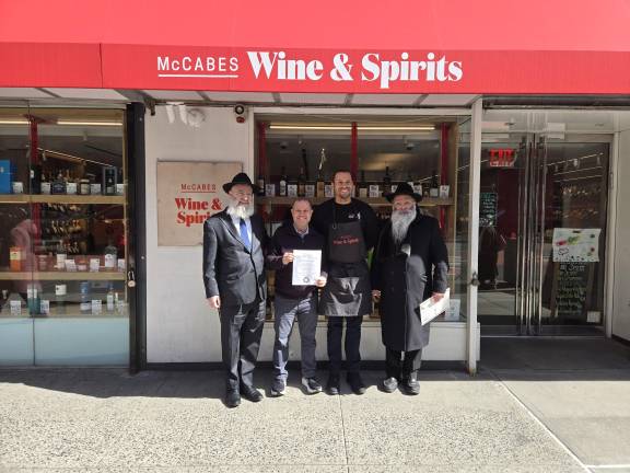 Despite the shops Celtic sounding name, McCabe’s Wine &amp; Spirits is a kosher liquor store owned by an observant Jewish proprietor Daniel Mesnik who must sell the store for the duration of Passover and then buy it back. From left: Rabbi Ben Krasnianski, Daniel Mesznik, Allen Alexis, Rabbi Kalman Weinfeld