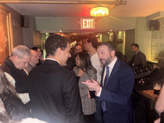 Keith Powers, who won the special election for New York State Assembly 74th District, gestures to his former City Council colleague Chris Marte at a victory party in Shades of Green Pub near Union Square.