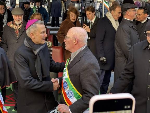 Archbishop Ronald Hicks greets grand marshal Bob McCann at the foot of St. Patrick’s Cathedral on March 17, 2026