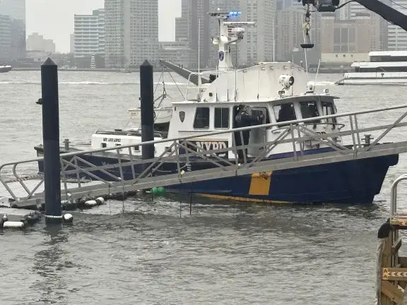 An NYPD boat returns to Pier 40 after assisting in the attempted rescue of six people who died when a sightseeing helicopter plunged into the Hudson River mid-afternoon on April 10.