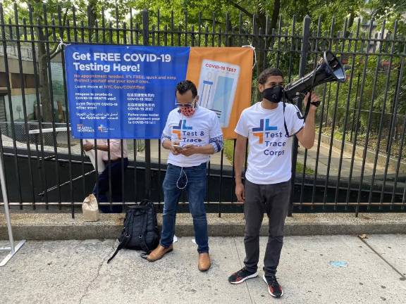 Volunteers urging New Yorkers to stop at St. James Recreation Center testing site on Fordham Road in the Bronx.