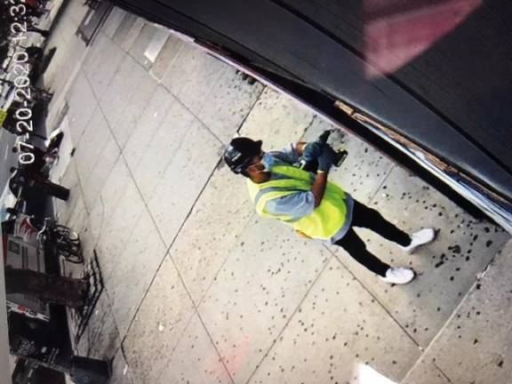 An unknown person — recorded on surveillance cameras — removes one of the murals outside a cordless drill.