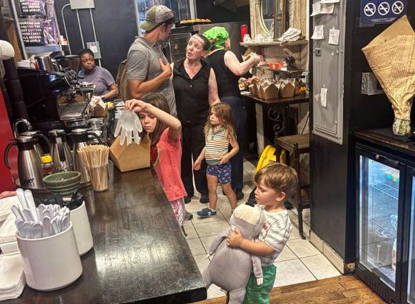 Mary O’Halloran (center in black) oversees a busy kitchen. She is chatting with Brandon Stanton, the founder of Humans of New York that featured Mary O’s Pub in a story five years ago that went viral and catapulted Mary O’s to national fame. Those are Stanton’s young children in the kitchen.