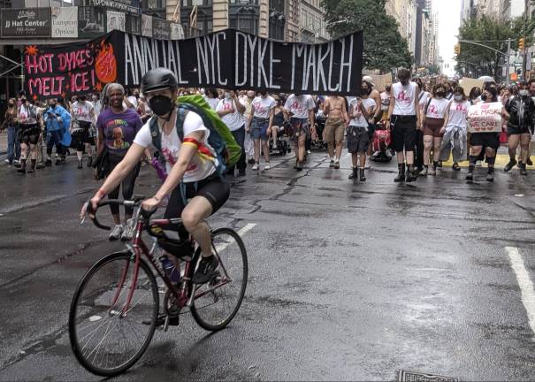 Dyke March with masking. Why? Reads one sign: “We mask because we care.”