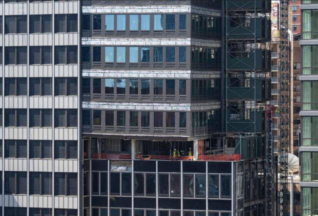 Workers can be seen inside the tower at 235 E. 42nd St. as they work to shore up the building after steel beams buckled on July 7.