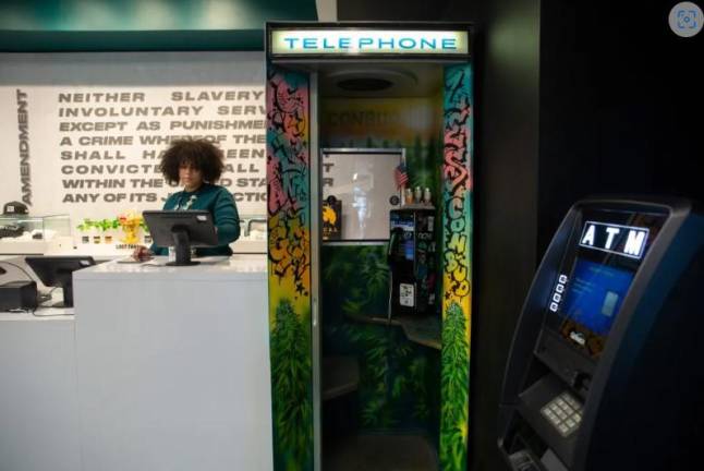 <b>A Conbud worker prepares for customers at the Lower East Side’s only state-licensed smoke shop, Jan. 4, 2024.</b> Photo: Ben Fractenberg/THE CITY