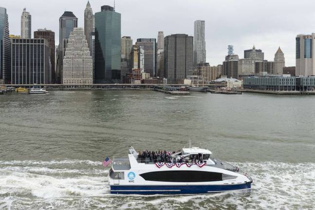 A NYC Ferry boat heads northbound up the East River opposite Fulton Street and the South Street Seaport in lower Manhattan. Starting on Aug. 15, an expansion of the city&#x2019;s ferry system will include a new route with a stop at the East 90th Street landing just above Gracie Mansion. Photo: NYC Economic Development Corp.