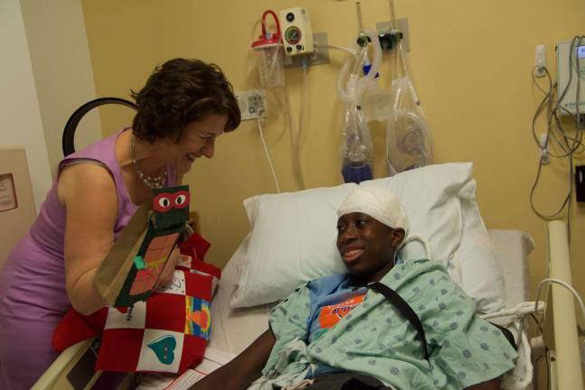 Lisa Buksbaum presents a puppet and other gifts to a patient at Beth Israel Medical Center. Photo: Angeline Eckbert