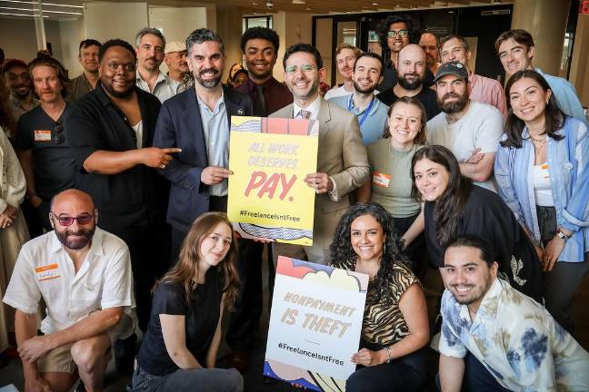 Freelancers Union “Freelance Isn’t Free Day” event, May 20. Kneeling with sign is Chief of Staff Andrea Gordillo; standing, bearded with sign, is FU’s former director Rafael Espinal.