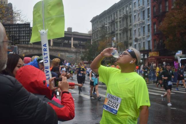 Simon Lee of Brooklyn, drinking some water before finishes the last ten miles of the race. Photo: Liz Hardaway
