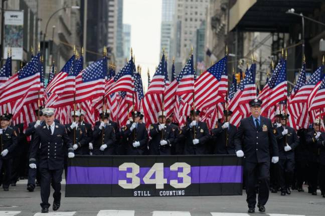 <b>FDNY members carry 343 American flags to memorialize the number of firefighters who died on 9/11 marching behind a banner of black and purple bunting with the words “still counting” to memorialize those who worked on the pile at the WTC and have continued to perish from 9/11 related cancers</b>. Photo: Michael Appleton/Mayoral Photography Office