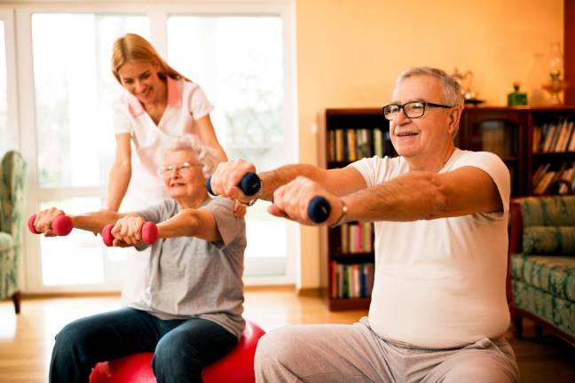 Working out with small weights and balance balls. Photo: istock.com/didesign021