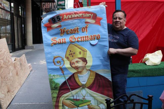 Willy Dominguez holds up poster for the festival while setting up. Photo: Gaby Messino